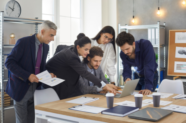 group of office staff looking at a laptop screen